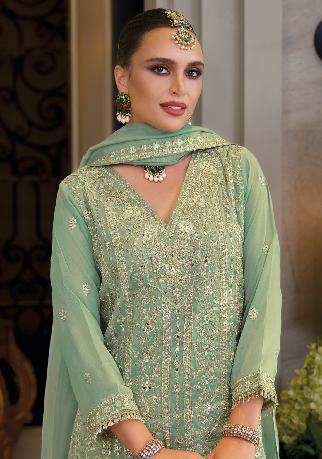 Front of a model standing wearing a green sharara.