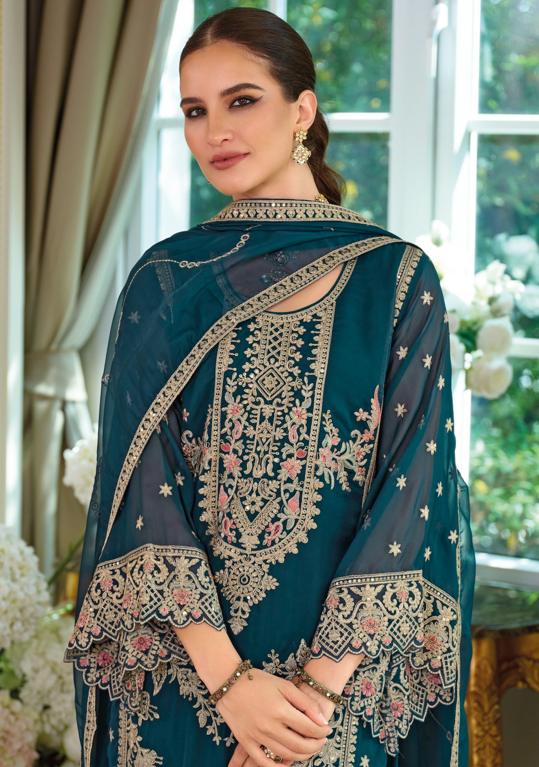 Front of a model standing wearing a teal Salwar Kameez.