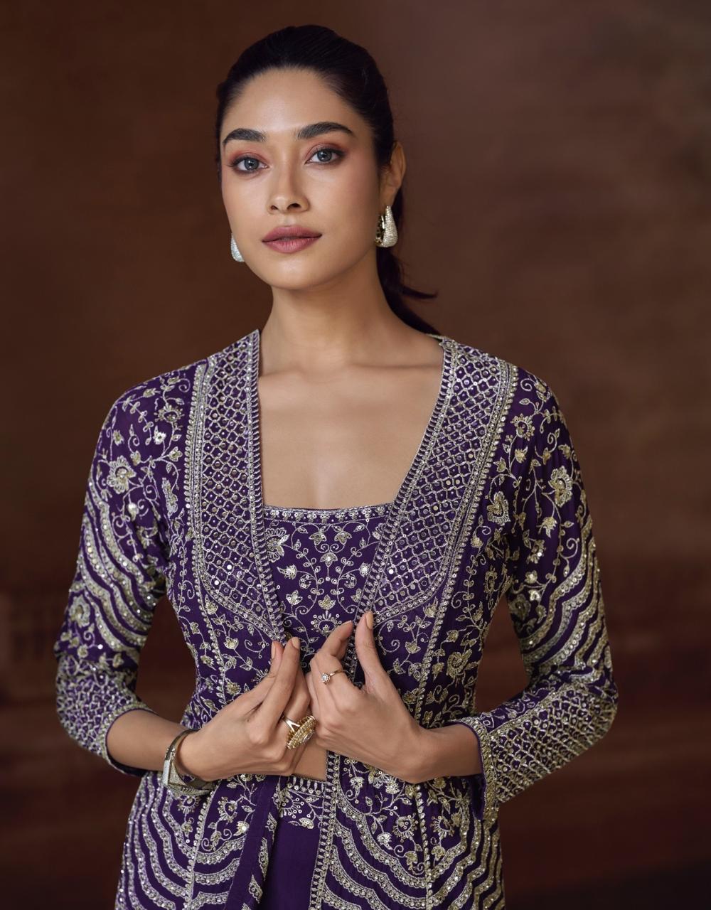 Woman wearing a purple and gold traditional outfit against a brown background