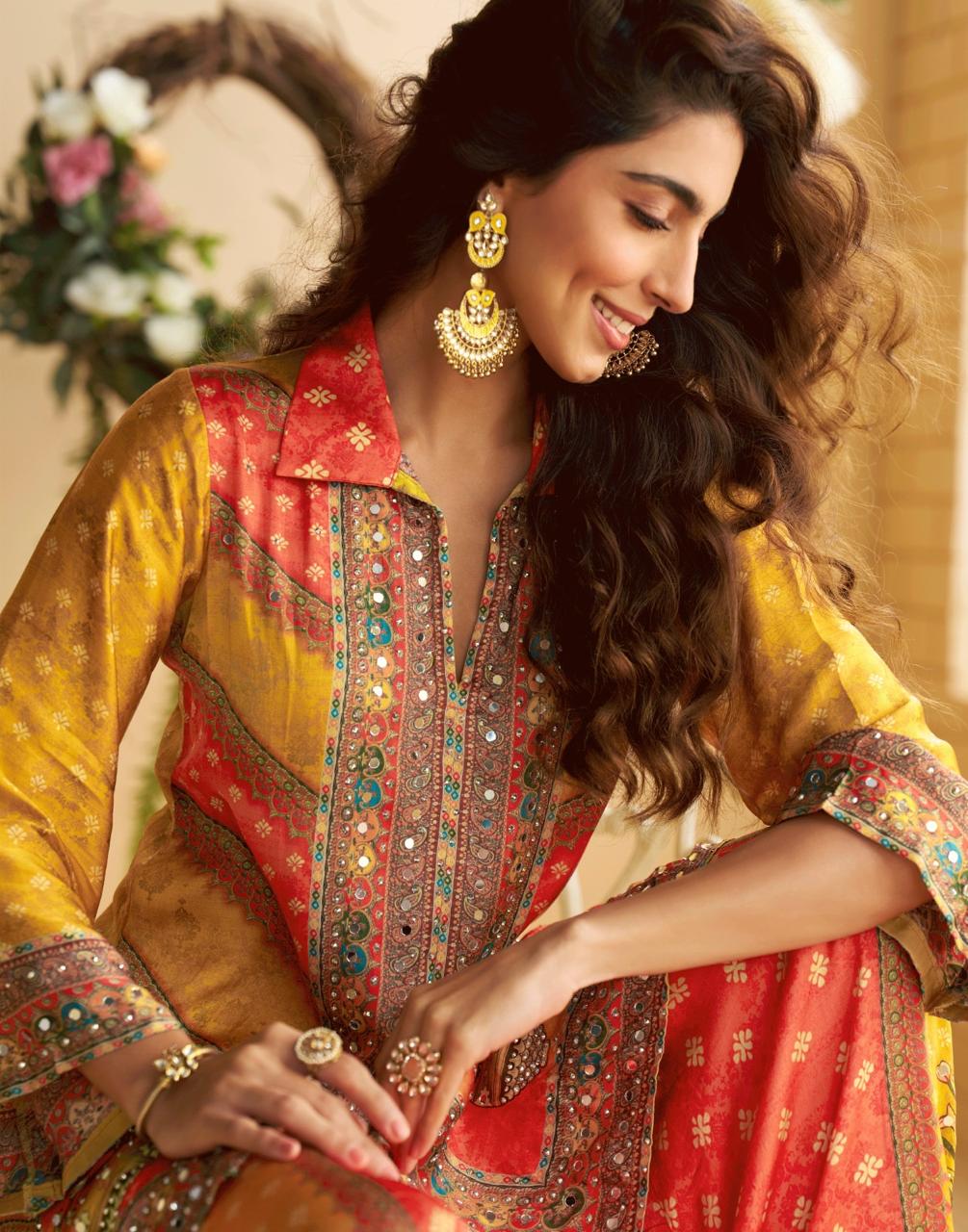 Woman wearing a colorful embroidered traditional outfit with gold jewelry.