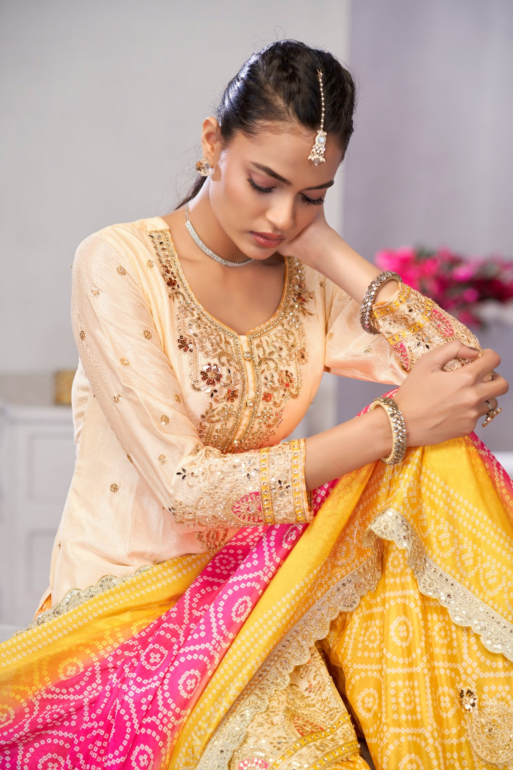 Woman in traditional Indian attire with a yellow and pink saree.