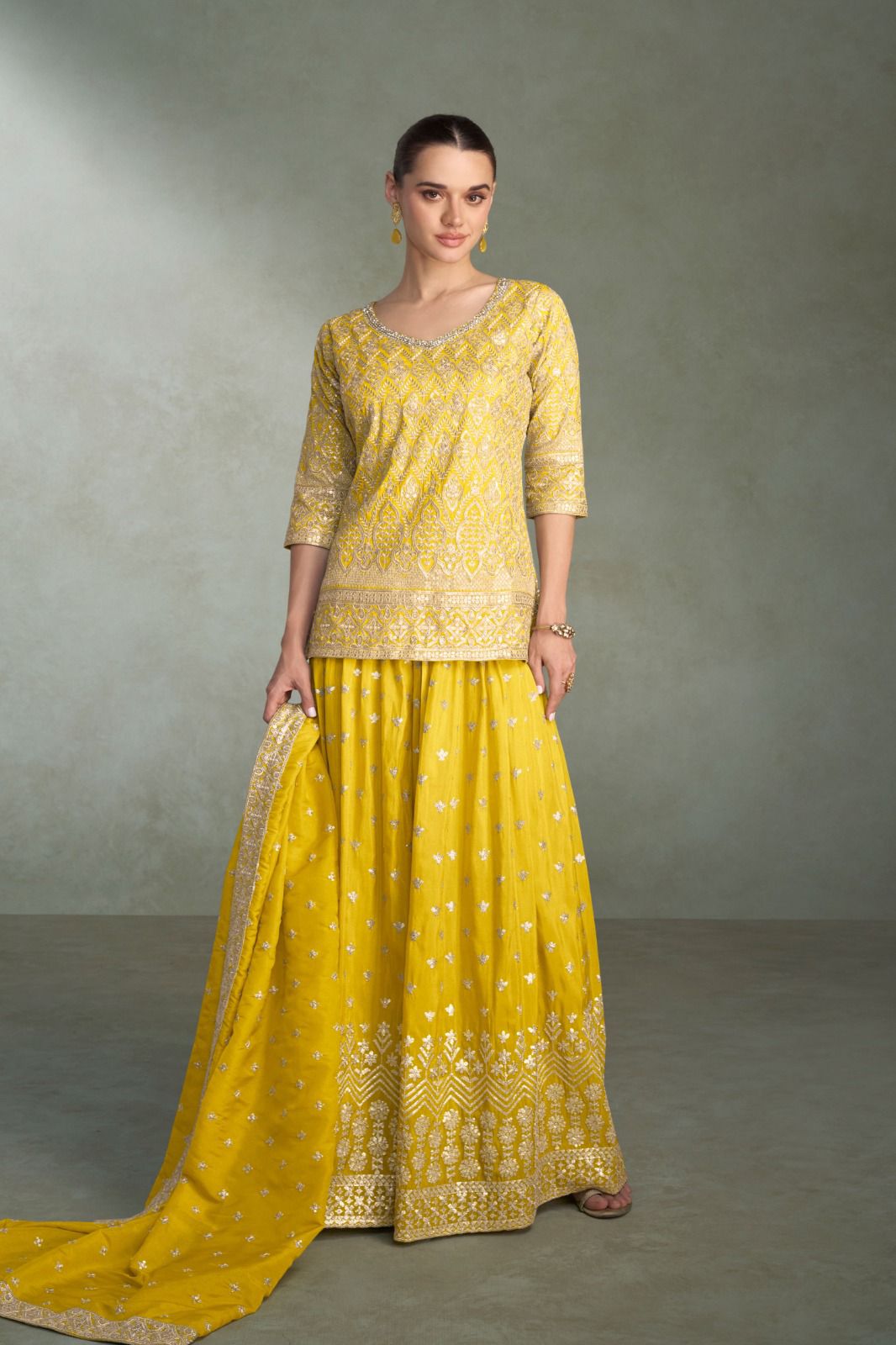 Woman wearing a yellow traditional outfit with a plain background