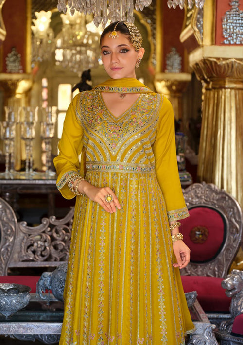 Woman in a yellow embroidered traditional outfit in an ornate interior setting