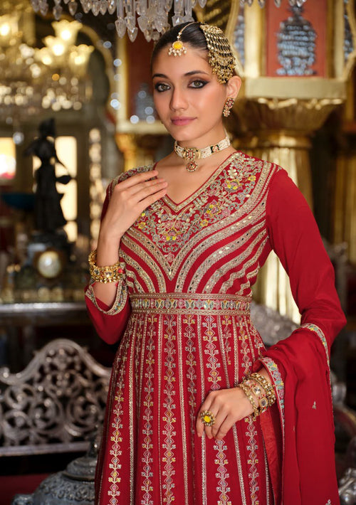 Woman in a red and gold traditional outfit with jewelry in an ornate setting